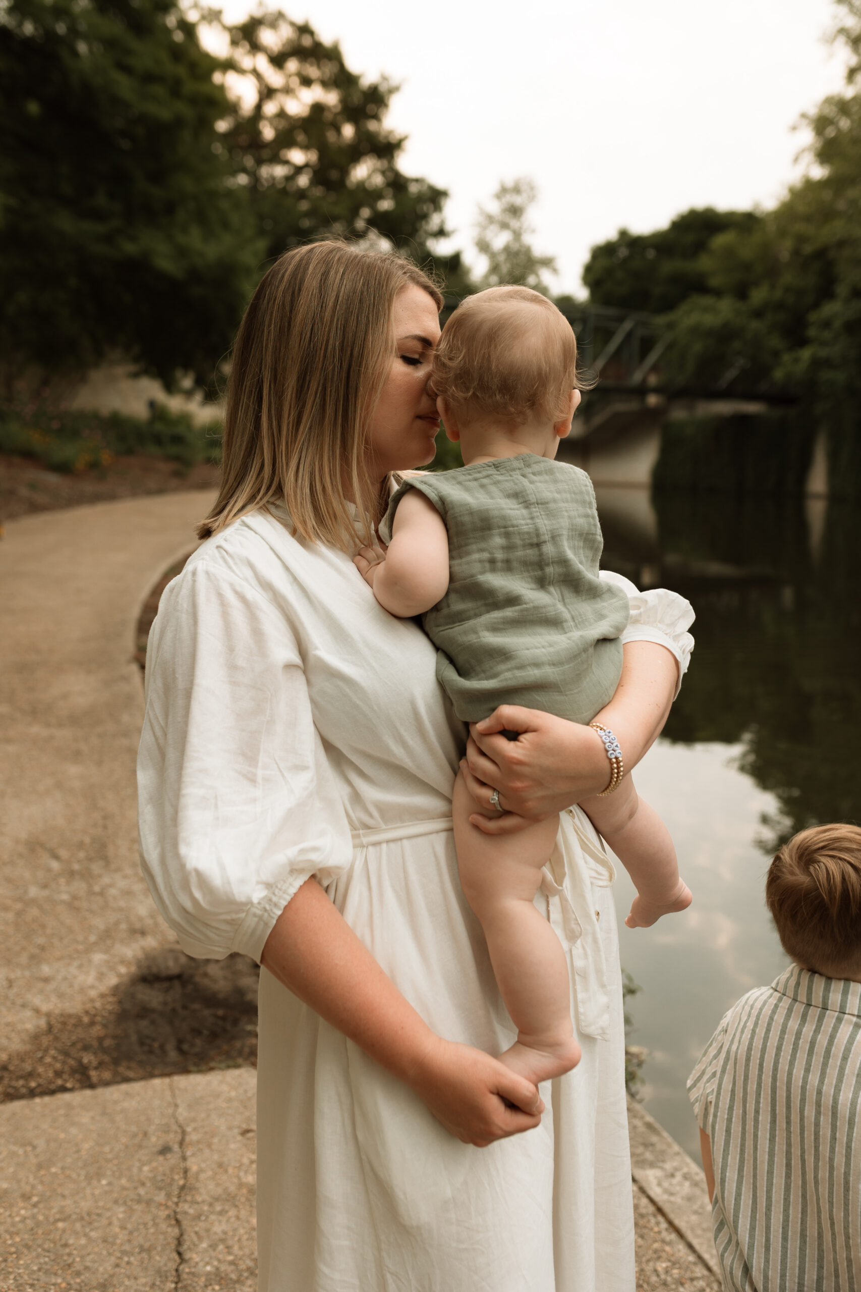 mother holding baby boy by the river