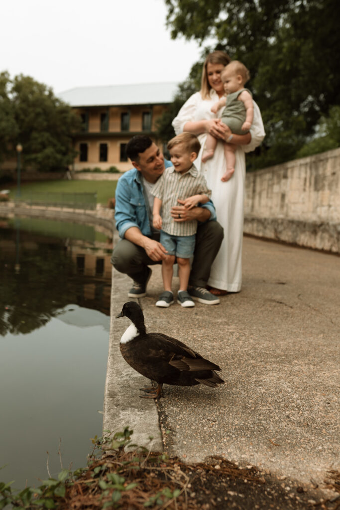 family looking at ducks along San Antonio River