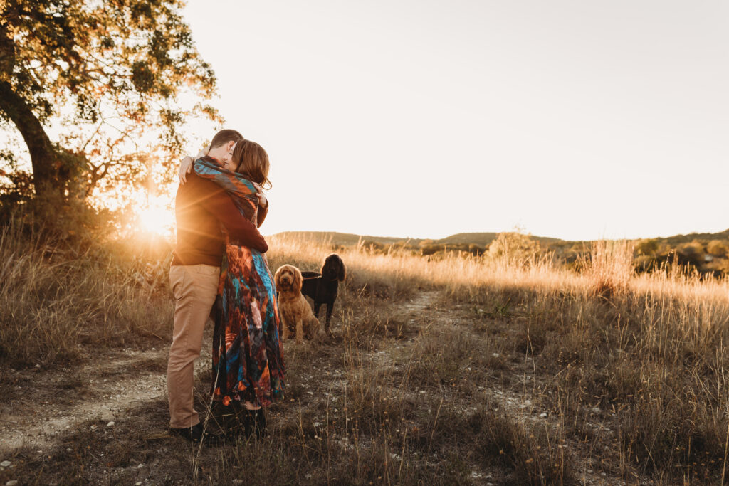 mom and dad embracing on hill top