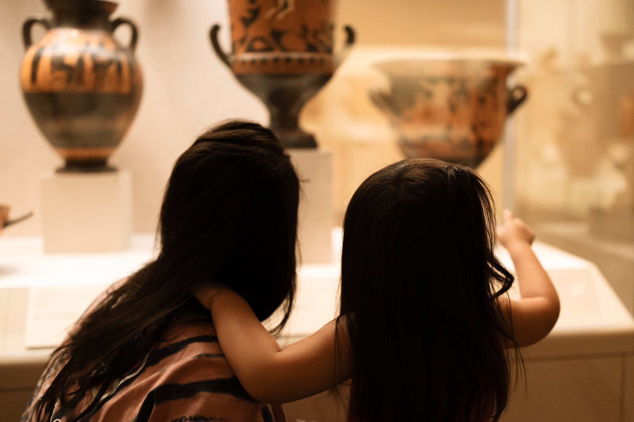 mom and daughter looking at artifacts in a museum