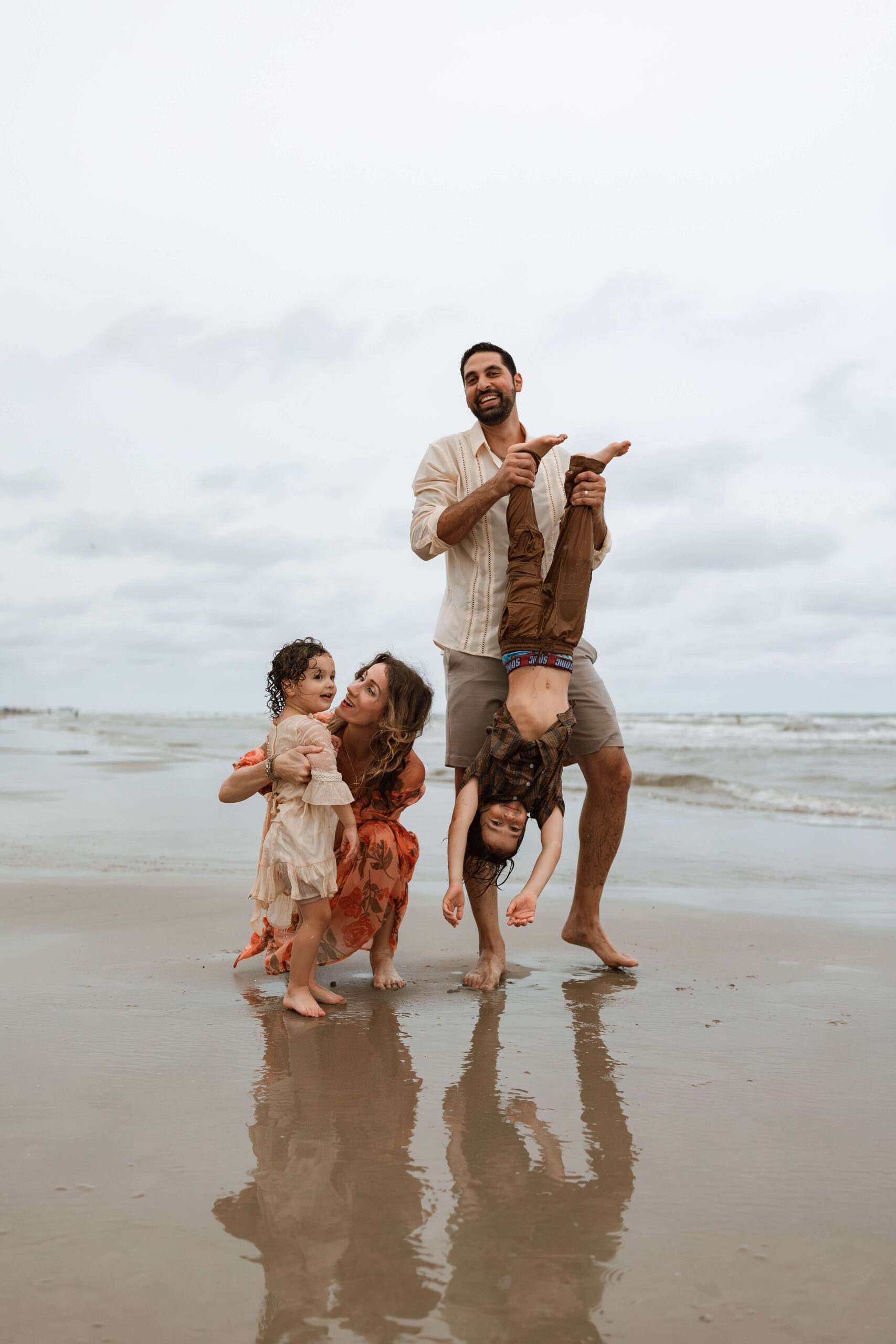 family of four playing at the beach
